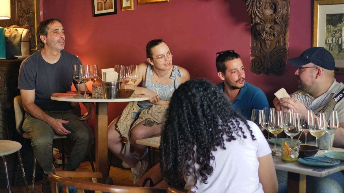 Convidados participando numa conversa guiada e prova de vinhos num bar intimista no Porto