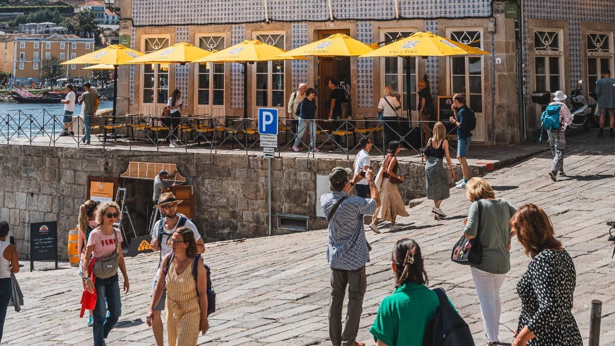 Tourists passing by the tiled building of Quinta do Vallado’s wine bar and shop in Ribeira
