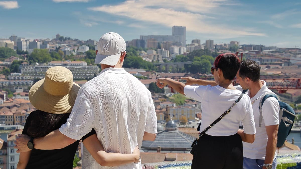 Casal e guia a apreciar a vista panorâmica sobre o Porto num dos melhores miradouros da cidade