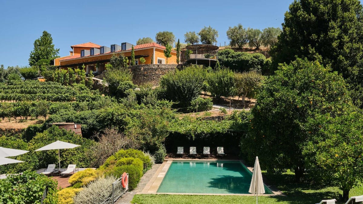 Vista da propriedade da Quinta do Vallado no Vale do Douro com vinhas em socalcos, piscina e arquitetura tradicional