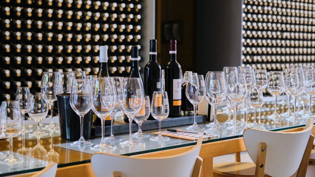 Garrafas de vinhos da Quinta do Vallado expostas numa mesa de degustação com copos e notas de degustação
